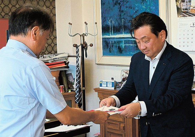 兼子史寛校長に目録を手渡す高橋宏聡社長(右)=益田市栄町、益田中学校