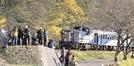 紅葉で色づいた山あいとともに奥出雲おろち号のラストランを撮影する鉄道ファン＝島根県奥出雲町八川