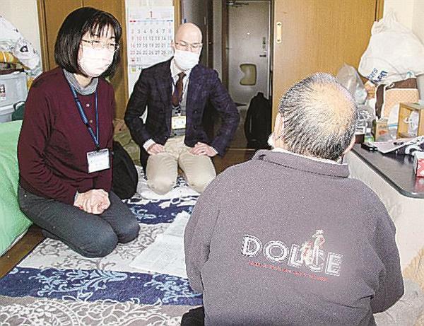 成年後見人の女性（左）に読んだ新聞記事の話をする男性（右）＝２０２２年１月、愛知県豊田市（資料）