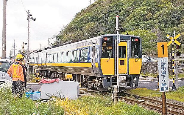 踏切制御盤（手前）が倒れた事故現場＝２８日午後５時５６分、出雲市多伎町