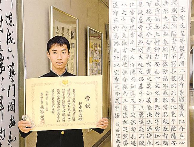 文部科学大臣賞の賞状を手にする柿永智哉さん。全国高総文祭の出品作（右）にも表れたしなやかな筆遣いが持ち味だ