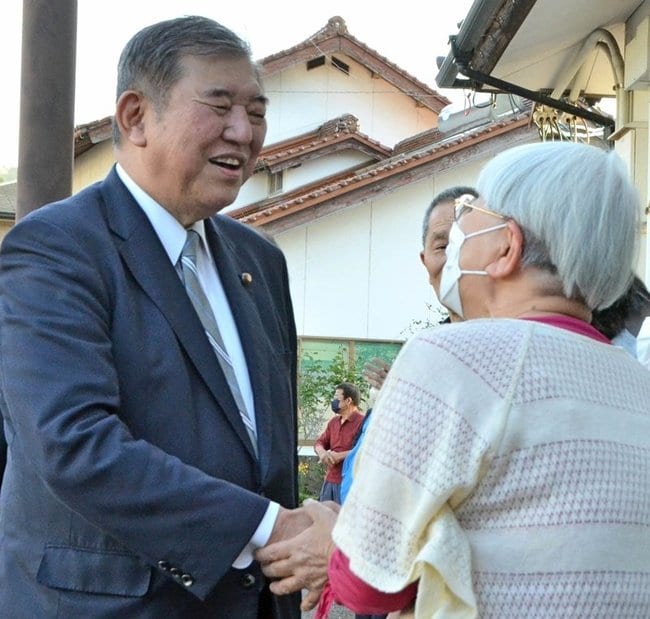 有権者と握手を交わす石破茂元党幹事長（左）＝１９日、雲南市内