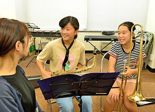 練習の合間に指導者（左）とふれ合う中村里帆さん（左から２人目）と壱岐彩乃さん＝江津市内の練習場