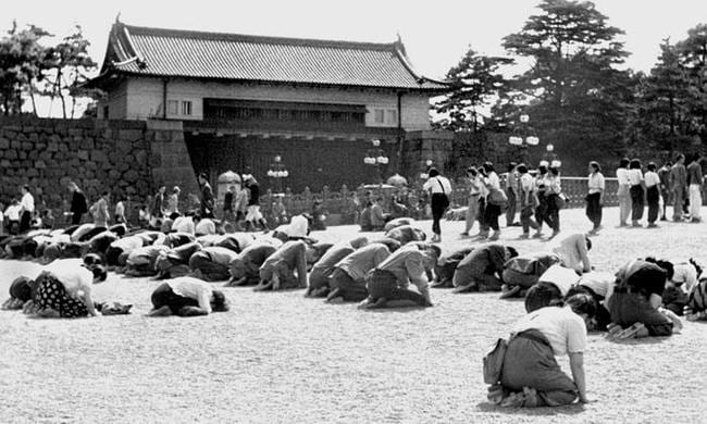 １９４５年８月１５日、昭和天皇の「玉音放送」で終戦を知り、皇居前でひざまずく人たち