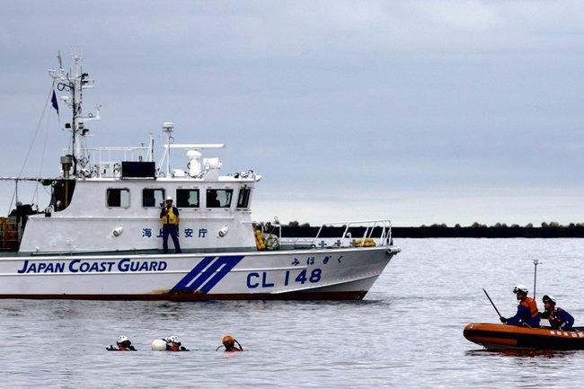転落した車が沈んでいると思われる地点で捜索をする鳥取県西部消防局の水難救助隊員ら＝１１日午後５時４７分、境港市竹内団地
