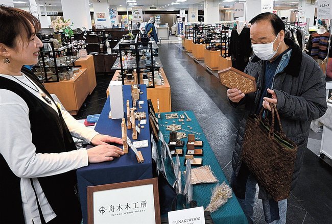 並べられた製品を手に取る来場者＝米子市角盤町１丁目、ＪＵ米子高島屋