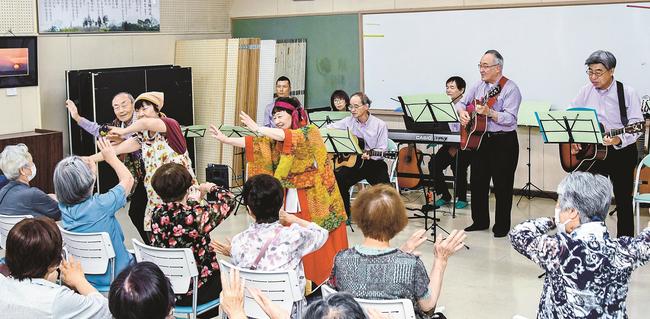 観客と一緒に手を振って踊るバンドのメンバー＝安来市荒島町、荒島交流センター