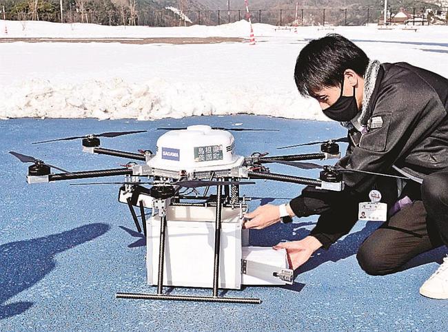 ドローンに荷物を載せる島根県美郷町職員＝同町久保、町防災公園