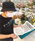 「浜田１８年ぶり甲子園」を伝える号外に目を落とす市民＝浜田市港町、ゆめタウン浜田