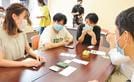カードゲームを楽しむ首都圏の大学生とメンバー＝松江市島根町加賀、島根公民館