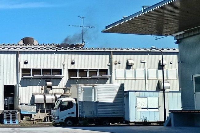 煙が上がる建物＝２８日午後３時４０分ごろ、松江市東出雲町錦浜