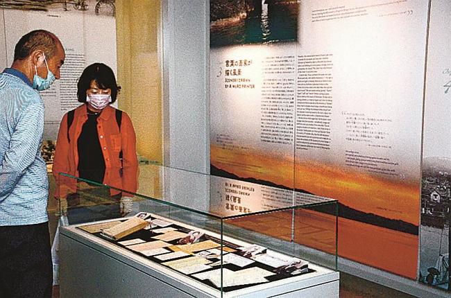 小泉八雲が書いた手紙に見入る来場客＝松江市奥谷町、小泉八雲記念館