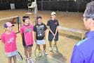 仲間たちとともに、コーチの言葉にうなずく大庭萌愛さん（左から２人目）と水永花音さん（同３人目）＝益田市乙吉町、益田運動公園益田庭球場