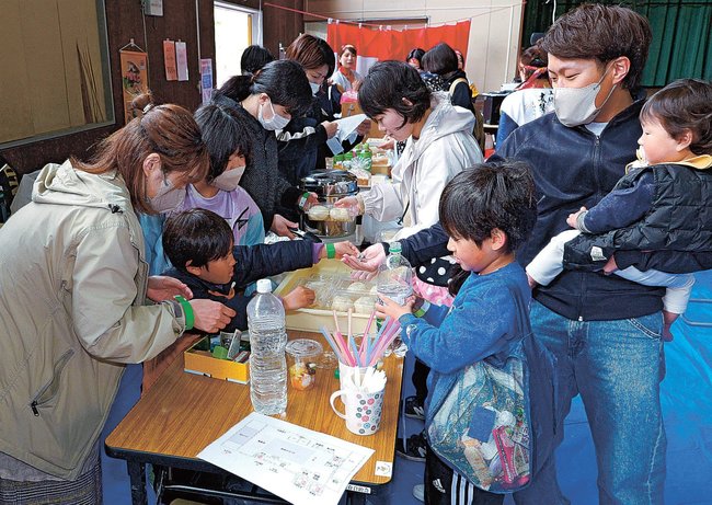 飲食物を買い求める来場者（右）＝島根県美郷町京覧原、君谷交流センター体育館