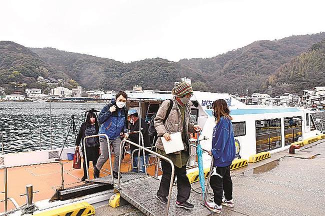 美保関漁港に到着したはくちょう号から下りる参加者＝松江市美保関町美保関