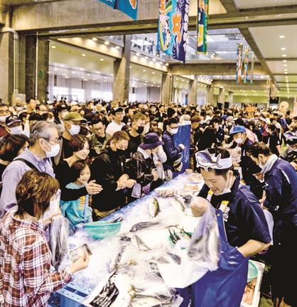 鮮魚などを買い求める来場者でにぎわう会場＝境港市昭和町、県営境港水産物地方卸売市場２号上屋