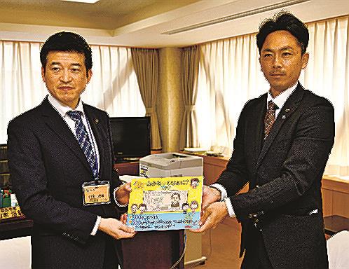 山本浩章益田市長（左）に絵本を手渡す田原亮輔会長＝同市常盤町、市役所