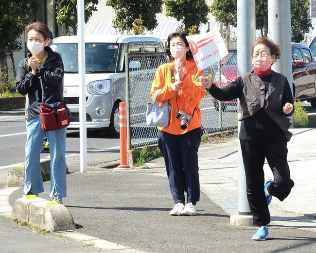 小旗を振ったり、拍手をして声援を送る市民＝出雲市斐川町荘原、第３中継所付近