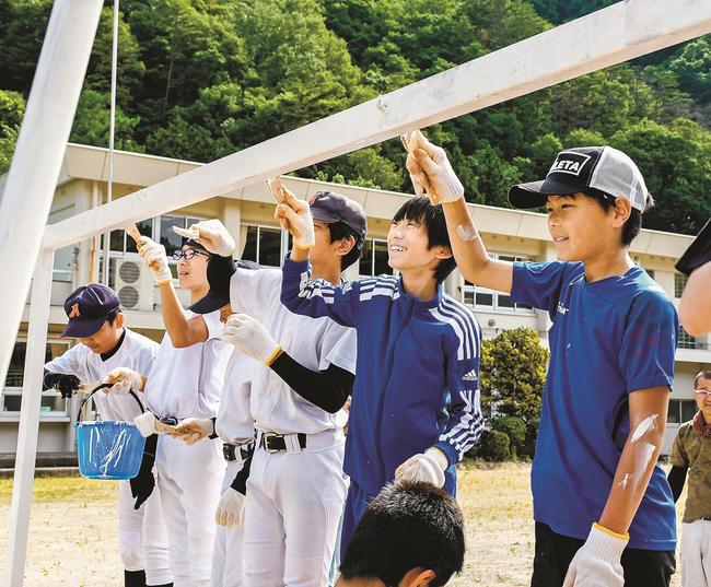 ゴールポストにペンキを塗る参加者＝島根県邑南町市木、市木小学校