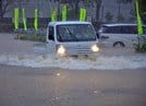 大雨の影響で冠水した道路を走る車＝１３日午前１０時４９分、鳥取市福部町内