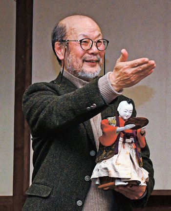 「茶運び人形」を手に講演する鈴木一義さん=島根県奥出雲町横田、雲州そろばん伝統産業会館