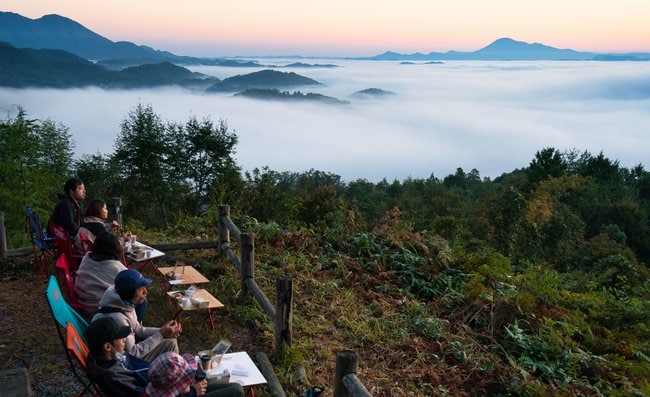 雲海を眺めながら朝食を味わう参加者=島根県川本町三原、丸山城跡
