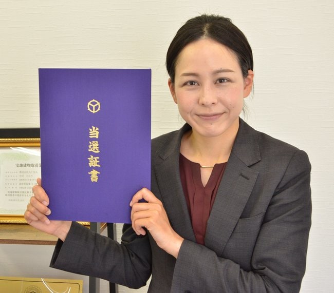 誇らしげに当選証明を掲げる中村ひかりさん