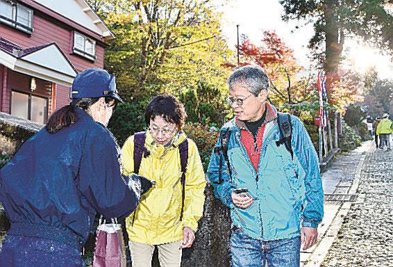 登山届の提出を呼びかけるチラシを配る署員（左）＝鳥取県大山町大山、大山寺参道