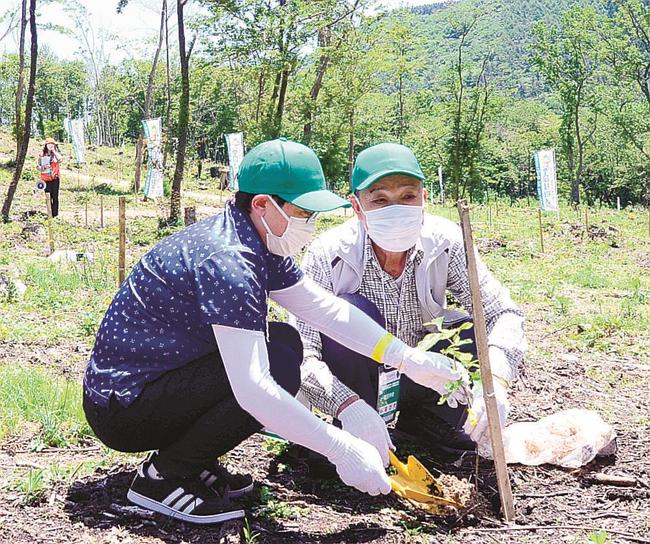 記念植樹に臨む一般参加者＝大田市三瓶町、三瓶山北の原