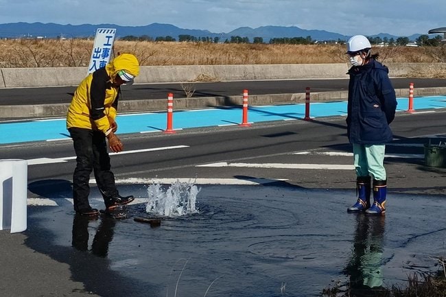 水漏れが発生したマンホールを修理する職員＝午後0時20分ごろ、島根県松江市東出雲町揖屋