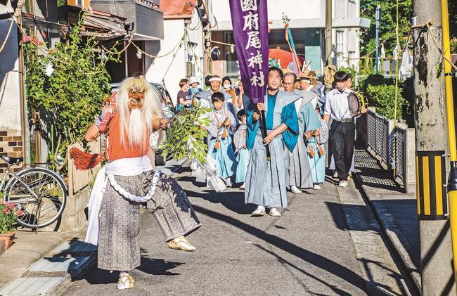 先払いの豪快な舞を先頭に練り歩く国府尾神社の氏子たち＝島根県隠岐の島町港町