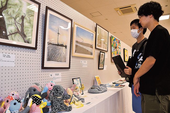 作業療法で作った絵画や手芸作品に見入る来場者＝益田市常盤町、キヌヤ益田ショッピングセンター