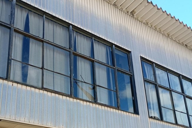 窓ガラスが割れた大東ふれあいセンター体育館＝６日午後１時58分、雲南市大東町下阿用