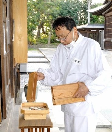 その日のおさい銭をまとめる、渡部律也宮司＝松江市殿町、松江神社
