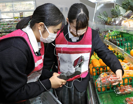 スマートフォンで店内の商品を撮影する生徒＝島根県吉賀町六日市、サンマート六日市店