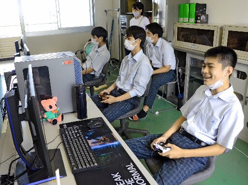 ロケットリーグの全国大会島根県予選で、ゴールが決まり喜ぶ部員たち＝安来市能義町、情報科学高校