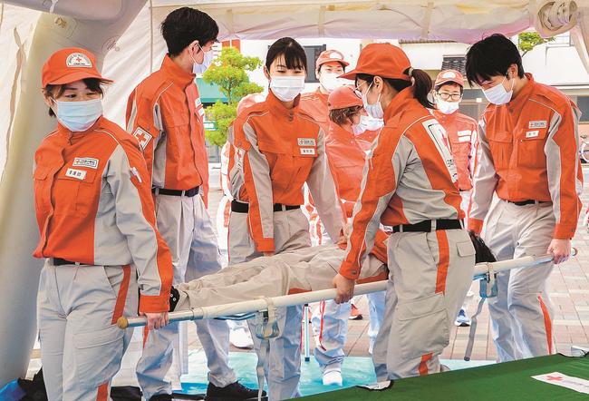 屋外に設置したテント内で災害時の搬送手順を確認する救護班員ら＝松江市母衣町、松江赤十字病院