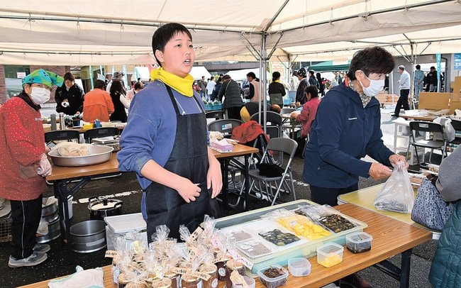 来場者に農産加工品を売り込む小学生(中央)=安来市伯太町東母里、市役所伯太庁舎駐車場