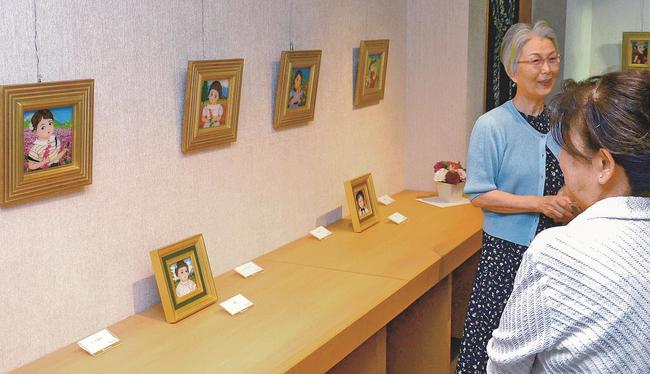 鮮やかなガラス絵を来場者に説明する丸山柚美さん（左）＝米子市角盤町１丁目、ＪＵ米子高島屋