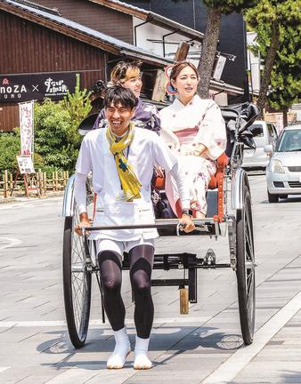 浴衣を着た女性を人力車に乗せ、神門通りを案内する糸賀太郎さん（手前）＝出雲市大社町杵築南