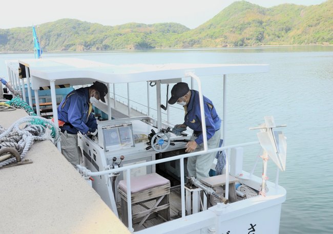 観光船のエンジンオイルなどの点検を行う乗組員＝松江市島根町加賀