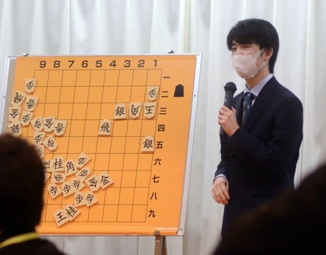 子どもたちに詰め将棋を出題する藤井聡太王将＝大田市三瓶町、国民宿舎さんべ荘