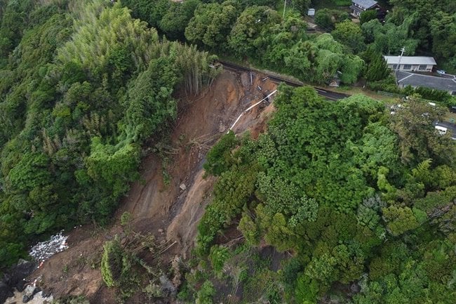 豪雨で県道が崩落した現場=10日午後3時16分、出雲市大社町日御碕(小型無人機で撮影)