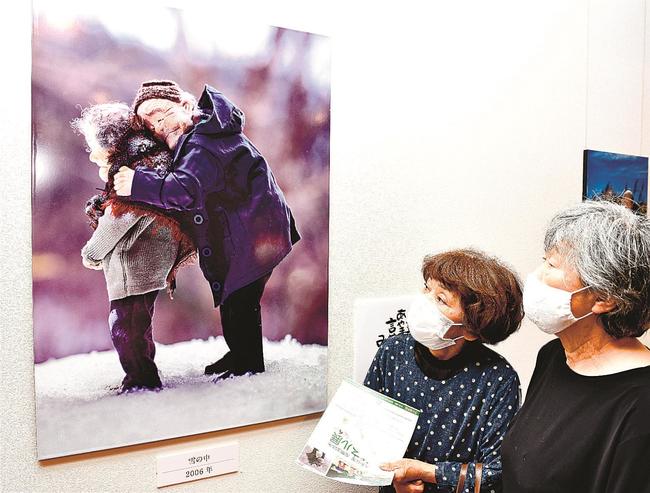 作品「雪の中」に見入る来場者＝江津市桜江町川戸、今井美術館