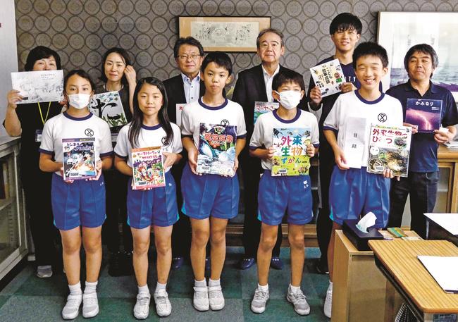 児童図書と目録を手にする蔵尾壮祐さん（前列右）ら高津小学校の児童たち＝益田市高津１丁目、同校