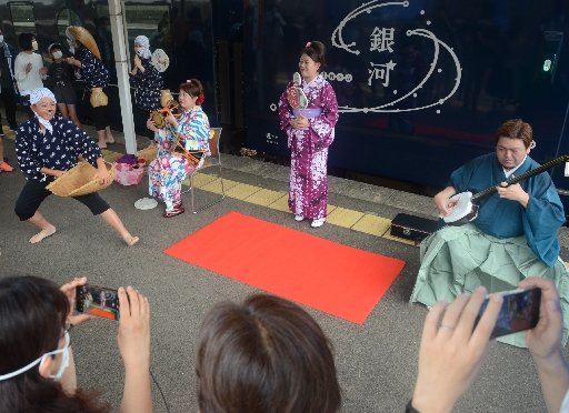 安来節のどじょうすくい踊りを披露する一宇川耕士さん（右）たち＝安来市安来町、ＪＲ安来駅