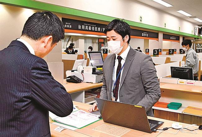 窓口で証明発行手続きに対応する市民課の職員(右)=益田市常盤町、市役所