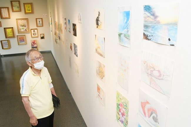 作品を見る来場者＝出雲市多伎町小田、海辺の多伎図書館