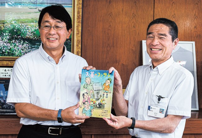 伊達憲太郎市長に絵本を手渡す中田耕治さん（左）＝境港市上道町、市役所