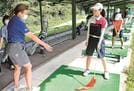 松澤知加子さん（左）から指導を受ける島根県ジュニア強化選手＝出雲市美野町、島根ゴルフ倶楽部